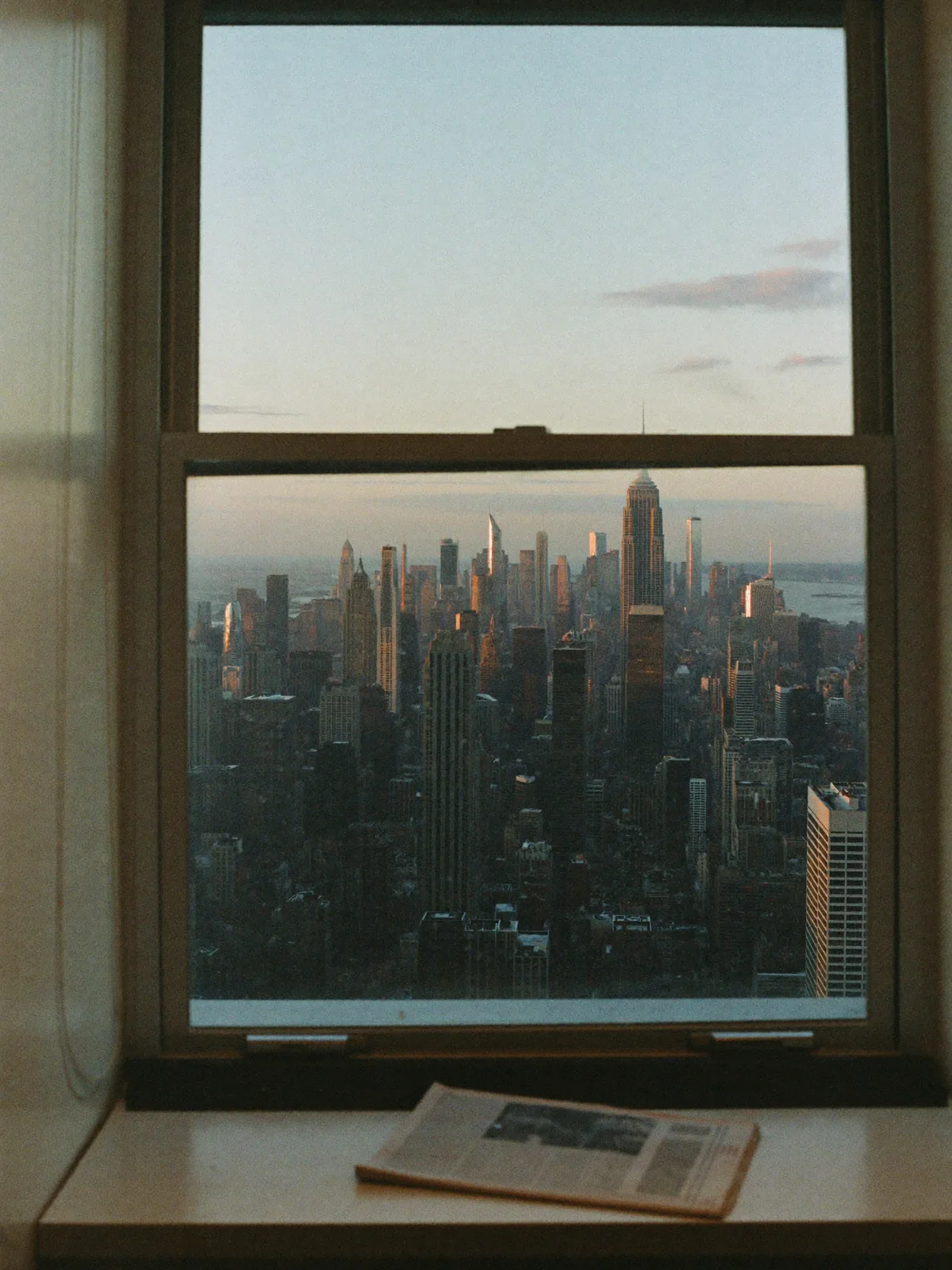 A city skyline at dawn through an office window